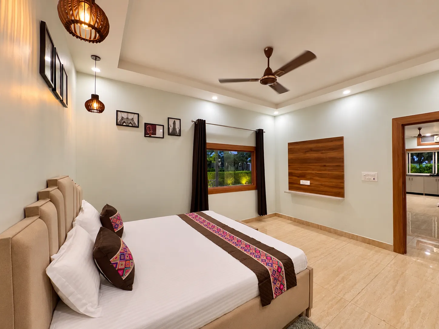 Bedroom two at Mulberry Farm — tan upholstered bed, ceiling fan and split AC
