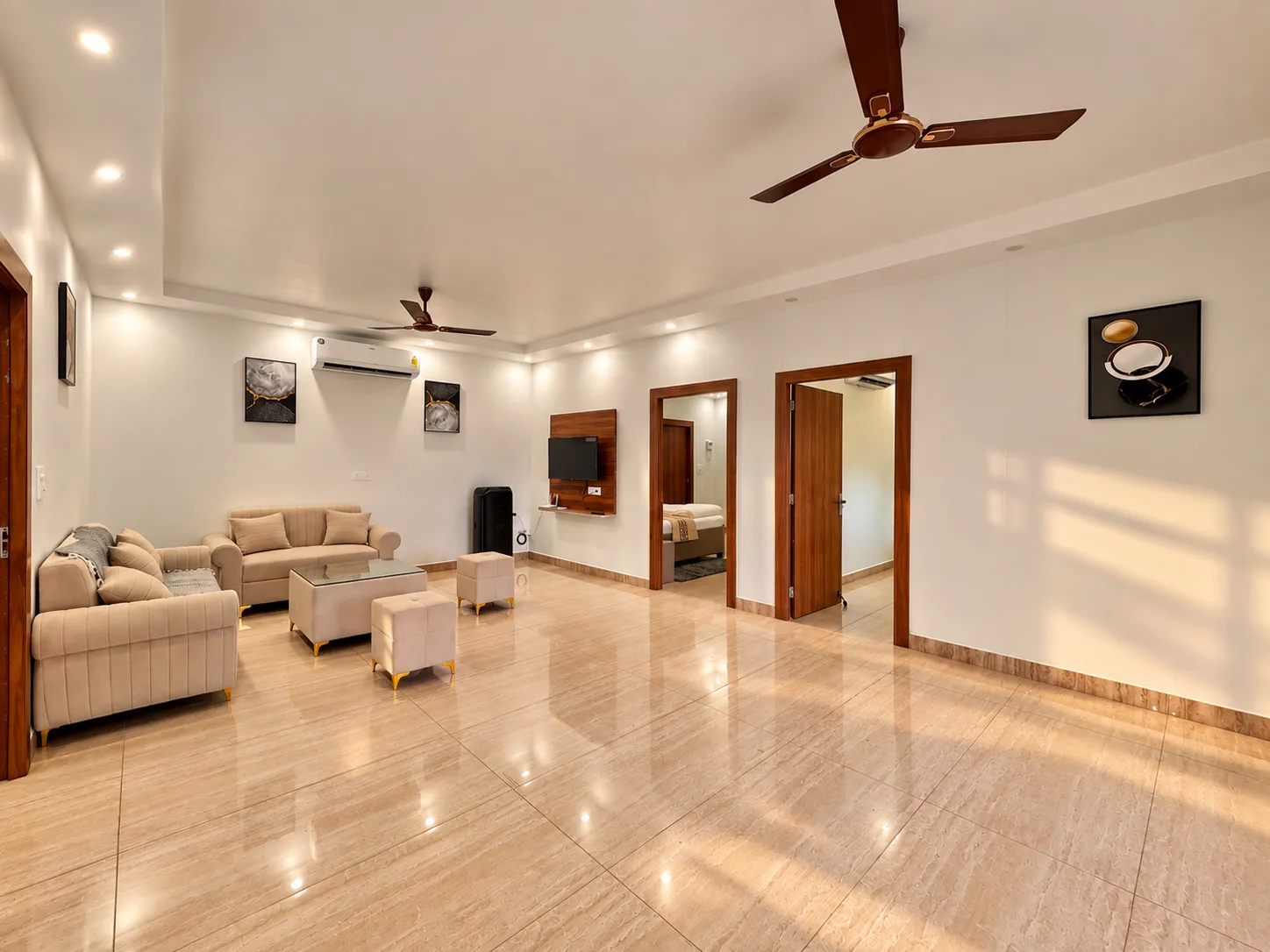 Seating and ottomans in the living room at Mulberry Farm, Noida
