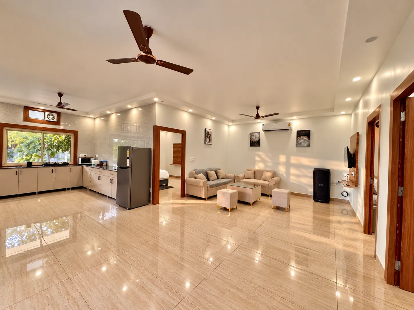 The living room at Mulberry Farm — sofas, ottomans and the JBL PartyBox, Sector 135 Noida